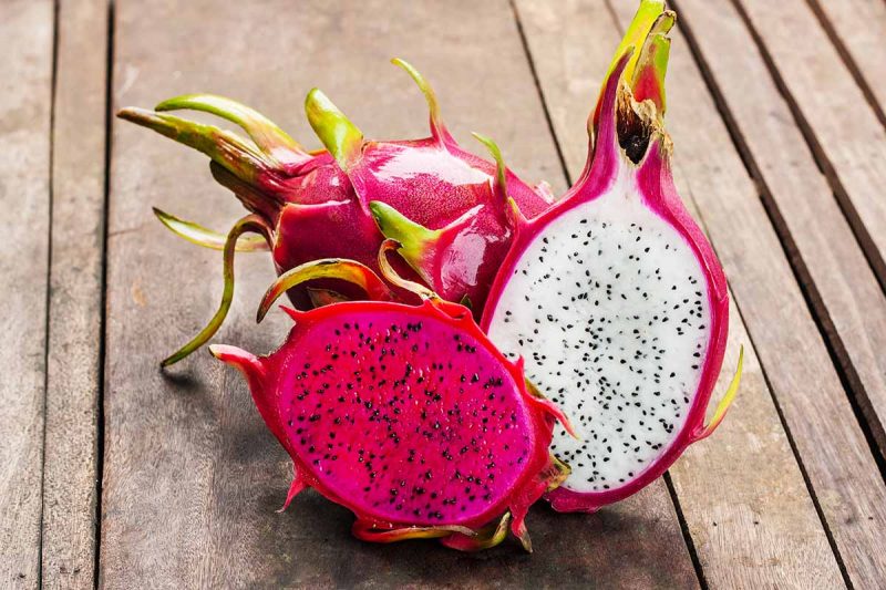 Red and pink dragonfruit on wooden vintage background